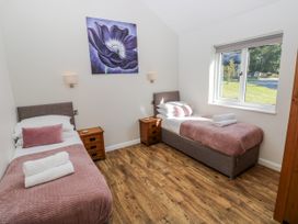 A bedroom with two beds and a painting at Dwrgi in Llanybydder