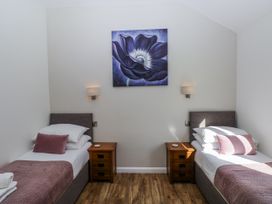 A bedroom with two beds and a floral painting at Dwrgi in Llanybydder