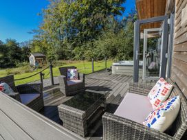 An outdoor seating area with a hot tub at Dwrgi in Llanybydder