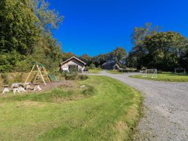 An outdoor area with two houses, a swing set, and soccer goals at Dwrgi in Llanybydder