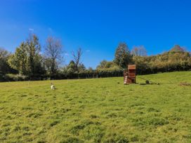 An outdoor area with a dog and a wooden structure at Dwrgi in Llanybydder
