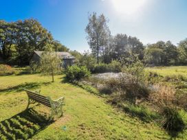 A bench near a pond and trees at Dwrgi in Llanybydder