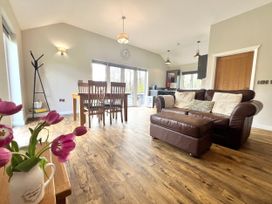 A living room with a sofa and dining area at Dwrgi Aber near Llanybydder
