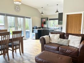 An open plan living and dining area with a dining table and sofa at Dwrgi Aber near Llanybydder