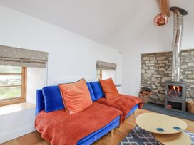 A living room with a blue sofa and a fireplace at The Old Dairy