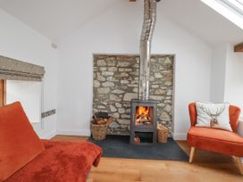 A snug with a wood stove and chair at The Old Dairy in 