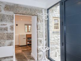 An entrance hall with a coat rack and view into the kitchen at The Old Dairy in 