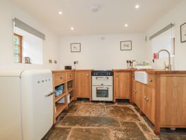 A kitchen with wooden cabinets and appliances at The Old Dairy 