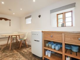 A kitchen with a SMEG refrigerator and wooden cupboard at The Old Dairy 