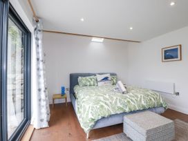 A bedroom with a bed, side table and window at The Old Dairy in 