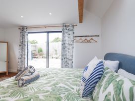 A bedroom with a bed and patio doors at The Old Dairy in 