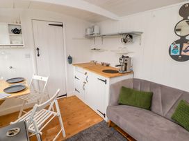A kitchen with a coffee machine and table at Shepherd's Hut in Perranarworthal