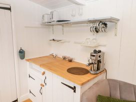 A kitchen with a sink and espresso machine at Shepherd's Hut in Perranarworthal