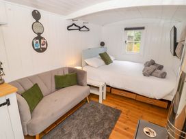 A bedroom with a sofa and bed at Shepherd's Hut in Perranarworthal