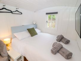 A bedroom with a bed and towels at Shepherd's Hut in Perranarworthal