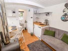 A kitchen with a table and chairs at Shepherd's Hut in Perranarworthal