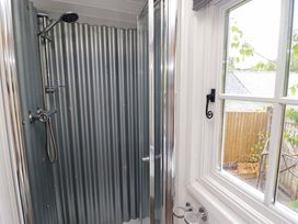 A shower with corrugated wall and window at Shepherd's Hut Perranarworthal