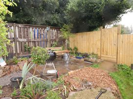 A garden with a barbecue and plants at Shepherd's Hut in Perranarworthal