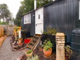 An exterior view of a hut with steps and planters at Shepherd's Hut in Pentyrch