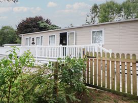 A cabin with a deck and fence at Delta Superior 