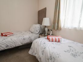 A bedroom with twin beds and a lamp at Delta Superior