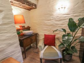 A sitting room with a chair and lamp at Penally Mews St Dogmaels