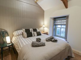 A bedroom with a bed and lamp at Penally Mews St Dogmaels