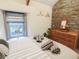 A bedroom with a bed and a dresser at Penally Mews St Dogmaels