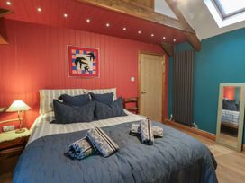 A bedroom with a bed and decor elements at Penally Mews in St Dogmaels