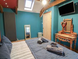 A bedroom with a bed and a dressing table at Penally Mews St Dogmaels