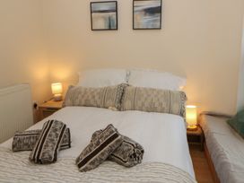 A bedroom with a bed and bedside table at Penally Mews St Dogmaels