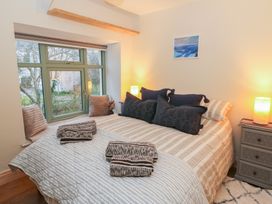 A bedroom with a bed and window at Penally Mews in St Dogmaels