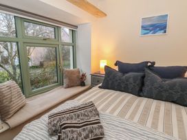 A bedroom with a bed and window at Penally Mews St Dogmaels