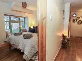 A bedroom with a bed and windows at Penally Mews in St Dogmaels