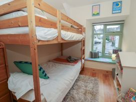 A bedroom with a bunk bed and single bed at Penally Mews in St Dogmaels