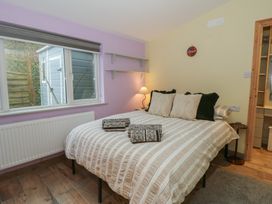 A bedroom with a double bed and shelves at Penally Mews in St Dogmaels
