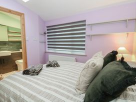 A bedroom with a bed and attached bathroom at Penally Mews St Dogmaels