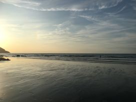 A beach with waves and sunset at Penally Mews St Dogmaels