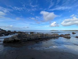 A beach with rocks and water at Penally Mews in St Dogmaels