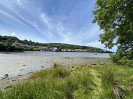 A river view with grass and boats at Penally Mews St Dogmaels