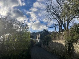 A view of trees and a building along a gravel pathway at Penally Mews in St Dogmaels