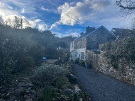A garden with a pathway and a house at Penally Mews in St Dogmaels