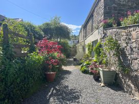 An outdoor area with a gravel path and flower pots at Penally Mews in St Dogmaels