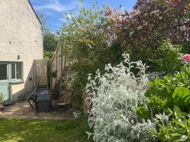 A garden with chairs and a table at Penally Mews St Dogmaels