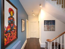 A hallway with paintings on walls at The Old Vicarage in St Issey