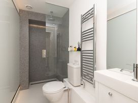 A bathroom featuring a shower, toilet, sink, and towel radiator at The Old Vicarage St Issey