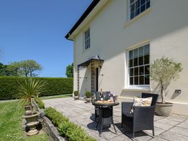 An outdoor seating area with a table and chairs at The Old Vicarage St Issey