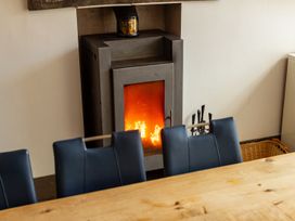 A dining room with a fireplace and wooden table at The Boundary in Windermere