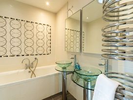 A bathroom with a bathtub and twin wash basins at The Boundary in Windermere