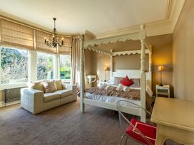 A bedroom with a four-poster bed and sofa at The Boundary in Windermere